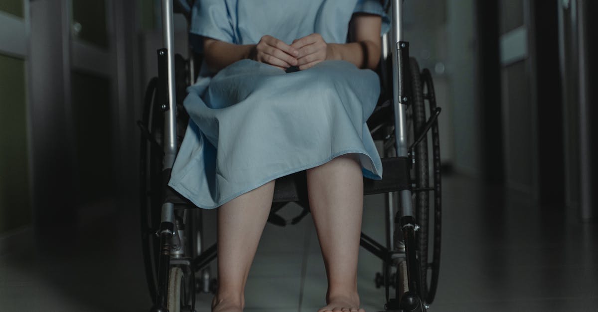 A person in a hospital gown sitting in a wheelchair