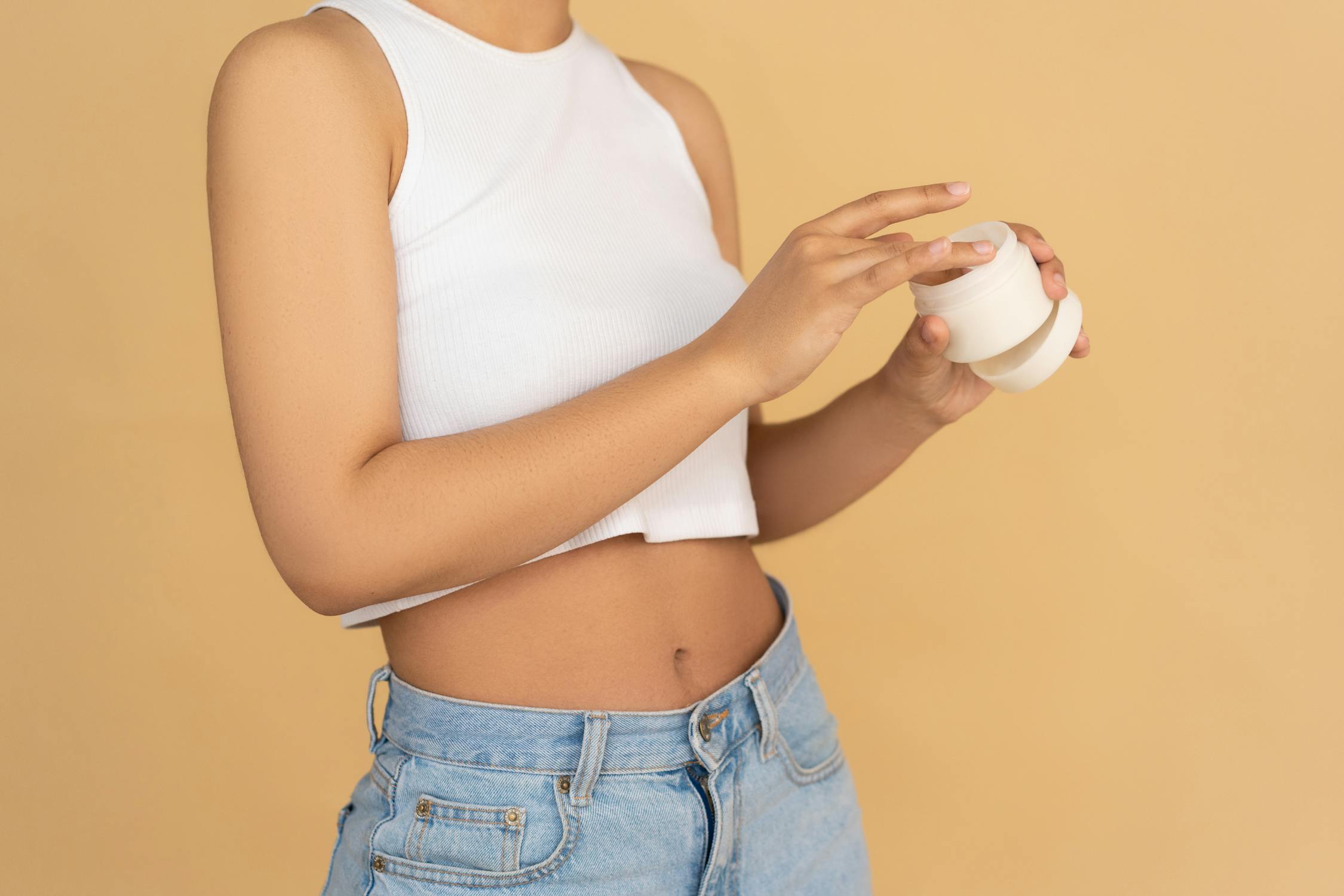 A person holding a jar of cream, illustrating the use of collagen products and exploring the potential risks and benefits discussed in the article 