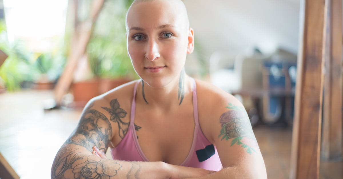 Eine Person mit Tattoos sitzt selbstbewusst da und symbolisiert Stärke, Hoffnung und Widerstandsfähigkeit.