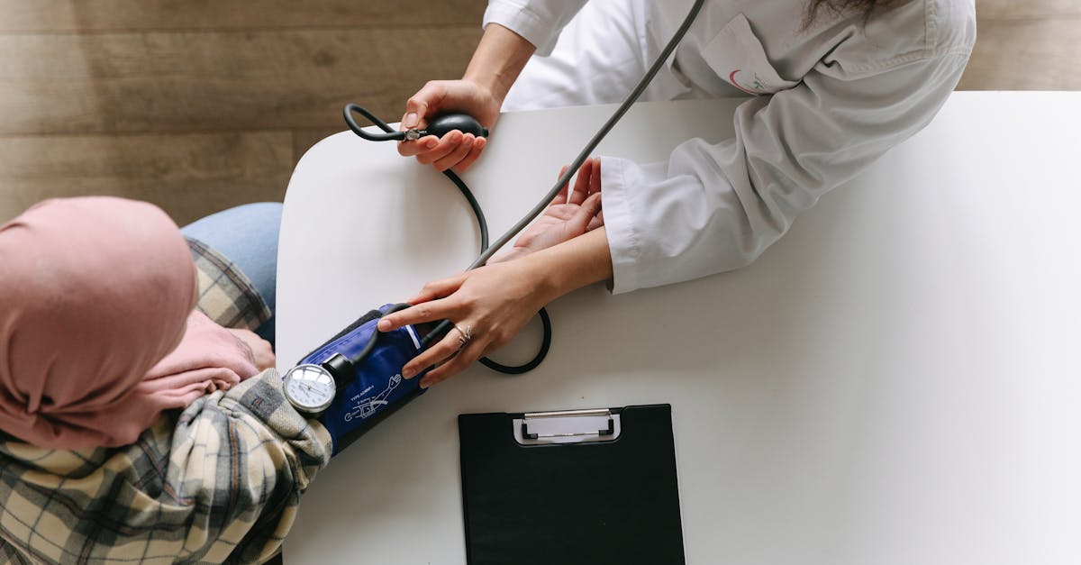 A healthcare professional measuring blood pressure of a patient with a clipboard nearby, symbolizing post-cancer treatment care.