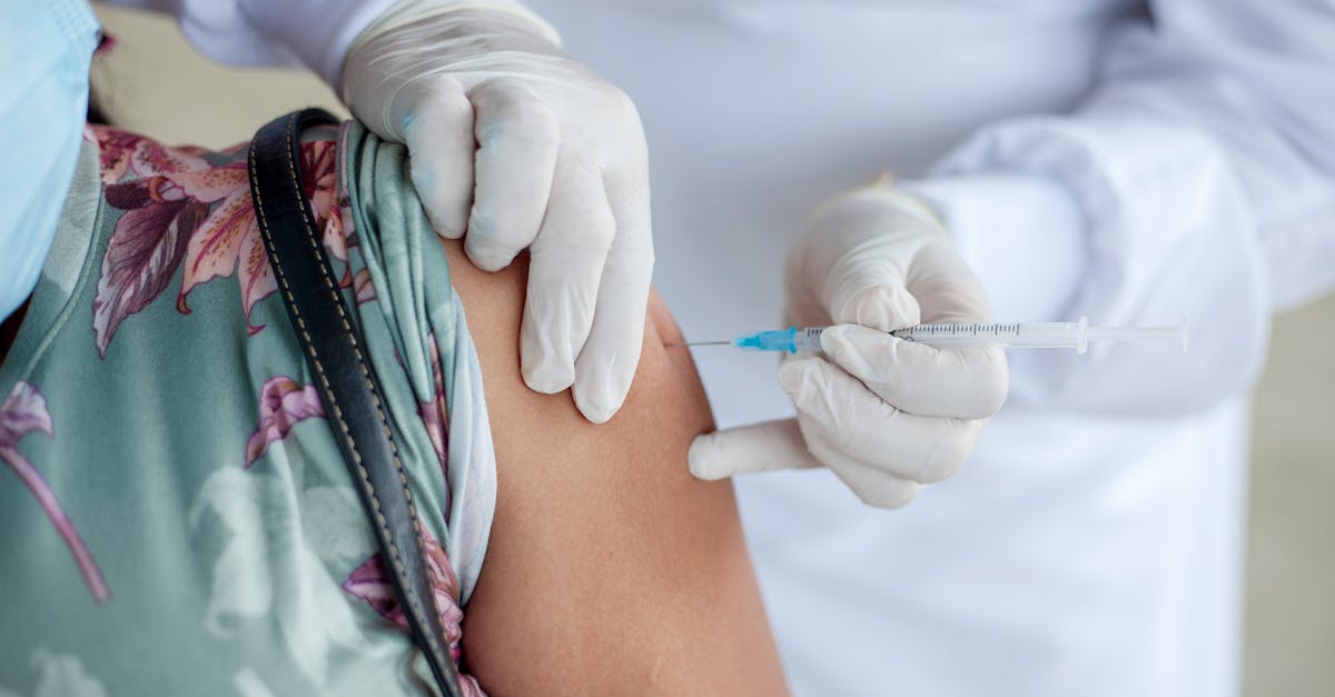 A healthcare professional in gloves administering a vaccine injection to a patient