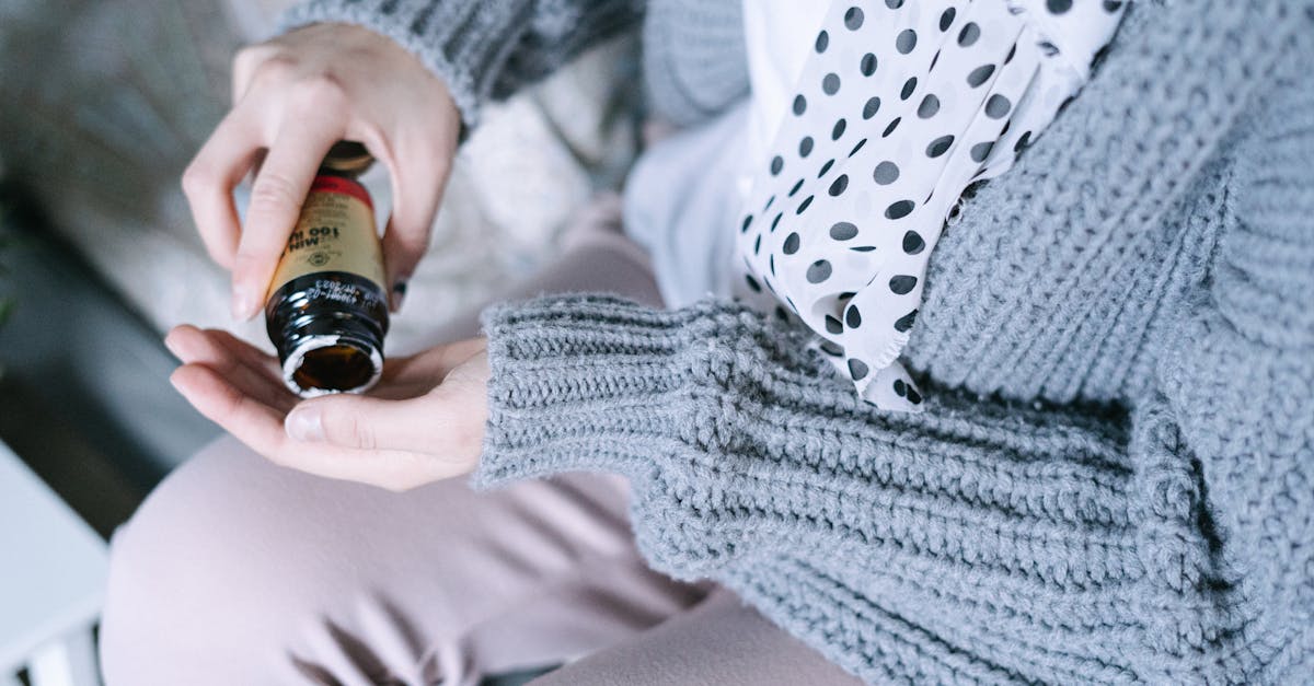 Osoba u udobnom džemperu koja drži bočicu vitamina, naglašavajući nutritivnu podršku tijekom oporavka od raka.