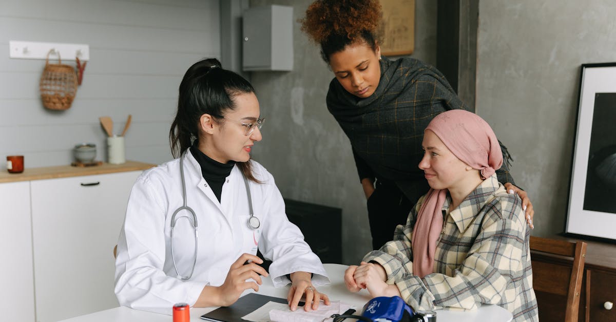 A compassionate doctor speaks with a cancer patient wearing a headscarf, while a supportive friend stands by, illustrating the importance of rebuilding relationships during recovery.