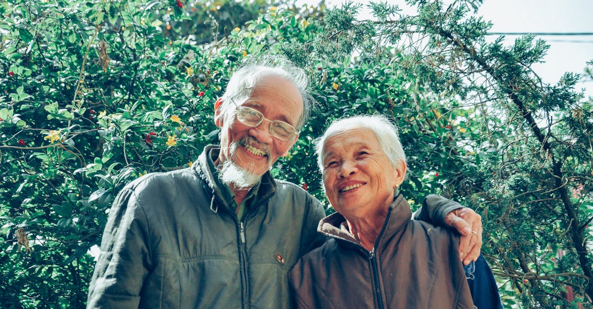 An elderly couple smiling outdoors in a garden, symbolizing family connections and genetic links related to hereditary cancer risks.