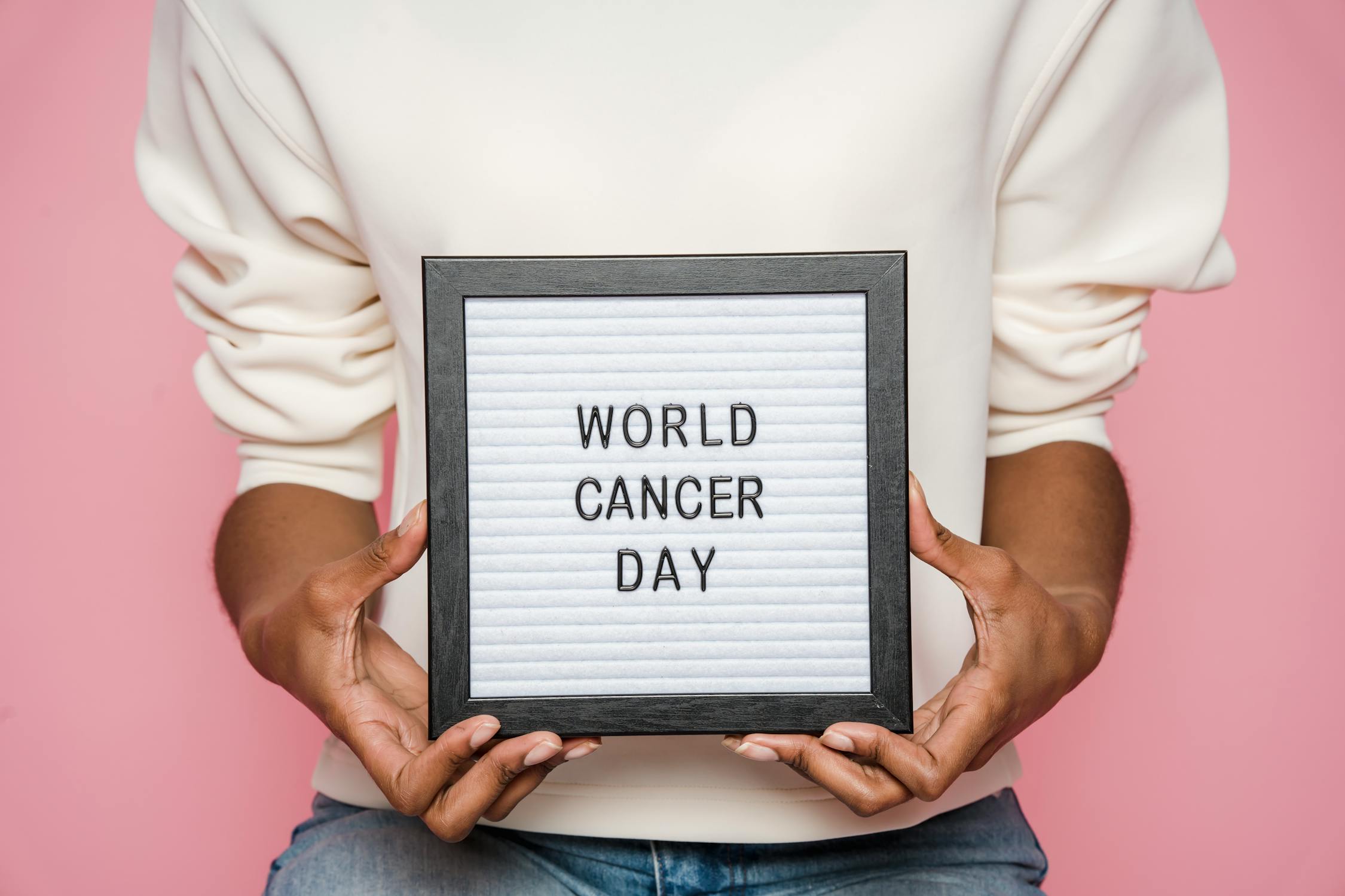 Person holding a framed sign with the words 'World Cancer Day' written on it